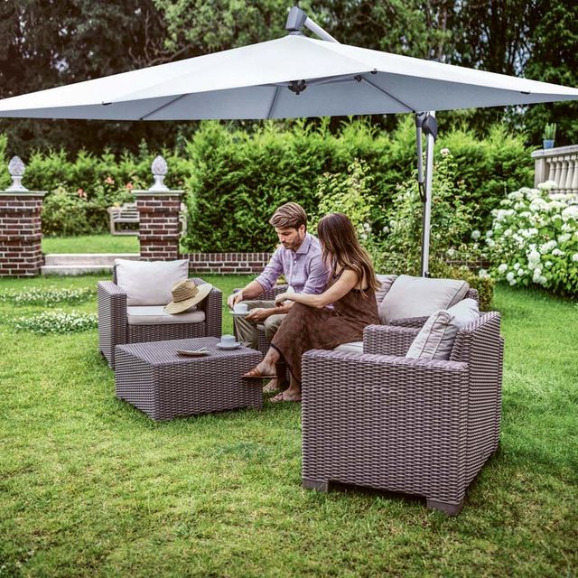 Pärchen sitzt im Garten unter Sonnenschirm